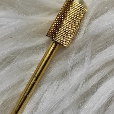 Ferramenta metálica dourada sobre superfície branca felpuda