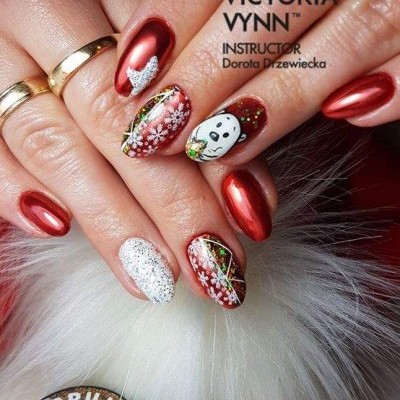 Unhas vermelhas metálicas e decoradas com tema natalício, mãos com anéis, frascos de verniz VICTORIA WYNN