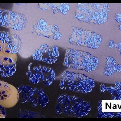 Adesivos para unhas azul marinho com padrões florais e arabescos em unhas bege claro