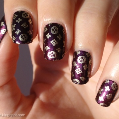 Unhas pintadas com verniz vinho metálico e padrões dourados