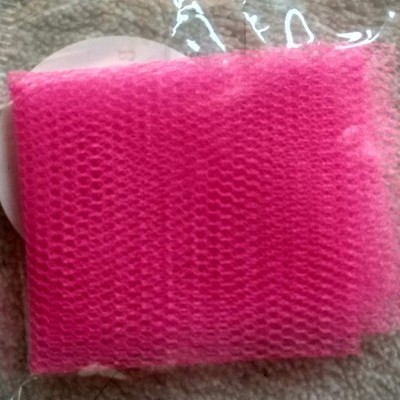 Pano de rede cor-de-rosa em embalagem plástica transparente