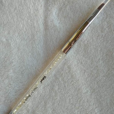 Pincel de maquiagem com cabo transparente e pérolas no interior