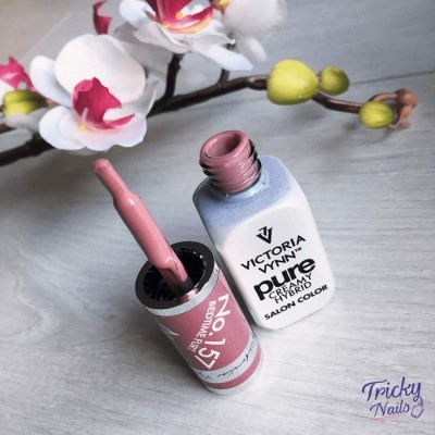 Verniz gel cor rosa claro da Victoria Vynn com embalagem branca e pincel aberto numa mesa cinza com flores artificiais ao fundo