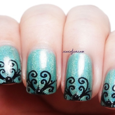 Unhas com verniz azul-turquesa e decoração preta elegante