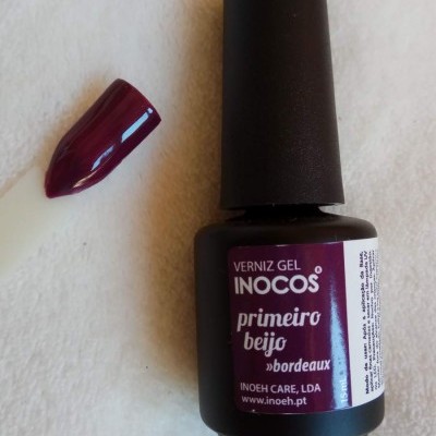 Frasco de verniz gel bordeaux INOCOS com amostra de unha pintada