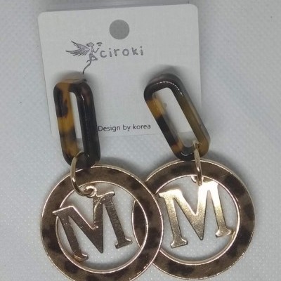 Brincos dourados com letra M e elo marmoreado castanho