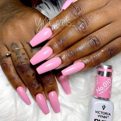 Mãos com unhas compridas pintadas de rosa com verniz Victoria Vynn