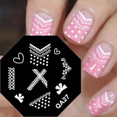 Estampas brancas para unhas em fundo preto com código QA27 ao lado de unhas decoradas cor de rosa com detalhes brancos