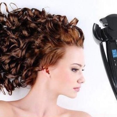 Mulher com cabelo encaracolado ao lado de modelador de cabelo preto com ecrã digital