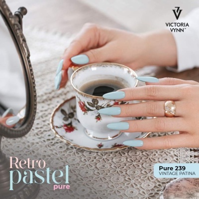 Mãos com unhas azul pastel segurando chávena de porcelana com flores vermelhas