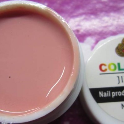 Frasco aberto de gel para unhas cor-de-rosa com tampa ao lado em superfície roxa