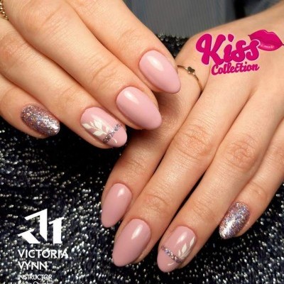 Mãos femininas com unhas rosas decoradas, anéis dourados, fundo preto texturizado