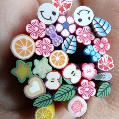 Pequenos bastões coloridos com desenhos variados na mão.