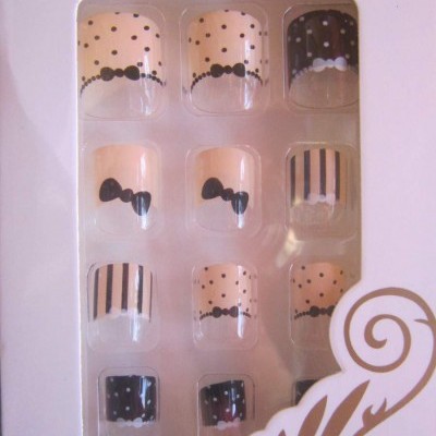 Conjunto de unhas postizas autoadesivas com padrões em bege, preto e branco na embalagem.