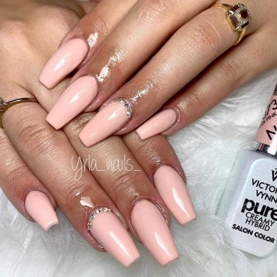 Unhas decoradas creme com pedras e verniz Victoria Vynn ao lado