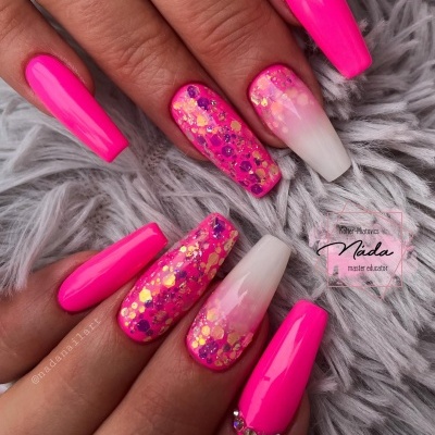 Unhas artificiais longas com verniz rosa fluorescente e decorações brilhantes