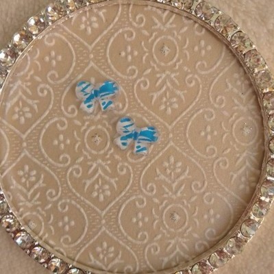 Porta-joias redondo com cristais e adesivos de borboleta azul no interior