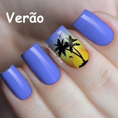 Unhas pintadas de azul com uma unha decorada com palmeiras e pôr do sol.