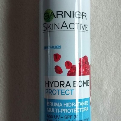 Frasco de spray facial Garnier SkinActive Hydra Bomb Protect com tampa transparente e texto em espanhol