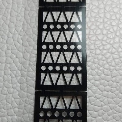 Placas pretas com padrão de triângulos e círculos sobre fundo branco texturizado