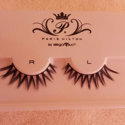 Conjunto de pestanas postas pretas em embalagem branca com texto e fundo de tecido cor de salmão