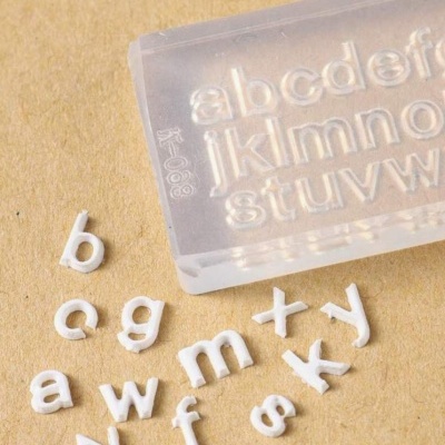 Conjunto de letras brancas de plástico e molde transparente com alfabeto em relevo