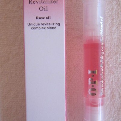 Frasco de óleo revitalizador para cutículas O.P.I com embalagem branca e rosa e imagem de rosas.