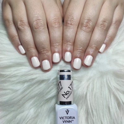 Unhas pintadas de branco creme com verniz Victoria Vynn No. 17 Fantasy sobre superfície branca felpuda.