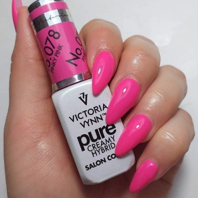 Mão com unhas rosa segurando verniz de unhas Victoria Vynn