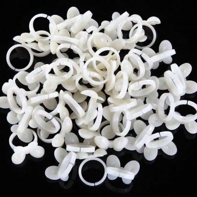 Anéis plásticos brancos em superfície preta reflexiva