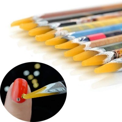 Pincéis para nail art com cerdas amarelas e cabos decorados aplicados em unha vermelha.