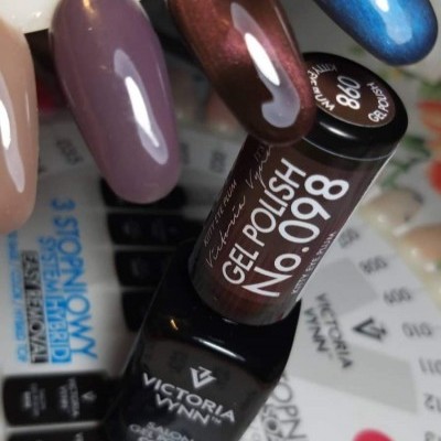 Frascos de verniz Victoria Vynn e amostras de unhas em várias cores sobre paleta numérica.