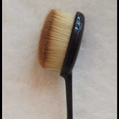 Escova de maquilhagem com cabo preto e cerdas castanhas