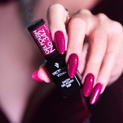 Mão feminina segurando verniz gel Victoria Vynn nº 342 e unhas pintadas de magenta brilhante
