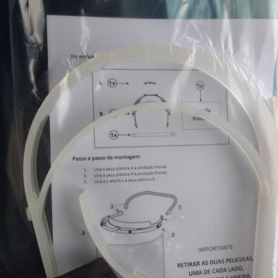 Peças plásticas brancas e elástico preto para viseira com instruções de montagem em português.
