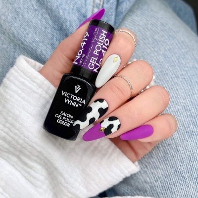 Mão feminina com unhas decoradas e frasco de verniz gel Victoria Vynn.