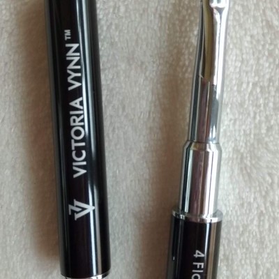 Pincel para unhas gel preto e prata com tampa preta sobre tecido claro