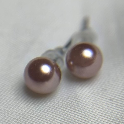 Brincos de pérola rosa em fundo branco texturizado