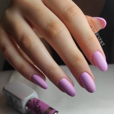 Mão com unhas pintadas de verniz roxo fosco e frasco de verniz rosa No.253
