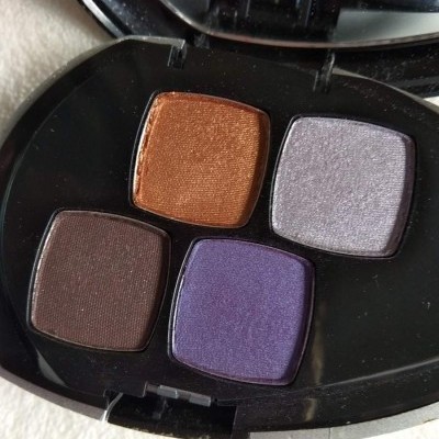 Paleta de sombras com quatro tons coloridos em caixa preta com espelho