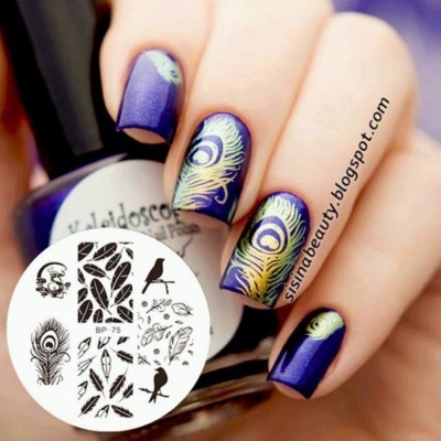 Unhas roxas com decalques de penas de pavão em verde e amarelo