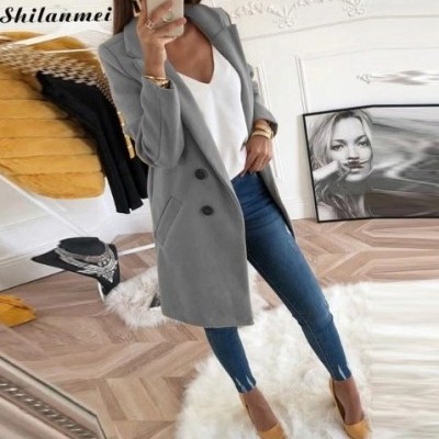 Casaco cinzento comprido com botões pretos usado com camisa branca, jeans e sapatos castanhos claros