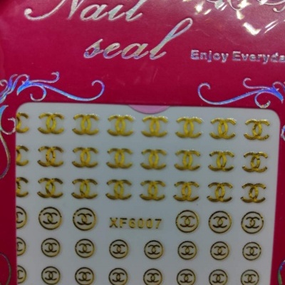 Autocolantes para unhas dourados com símbolos CC e texto Chanel em embalagem vermelha