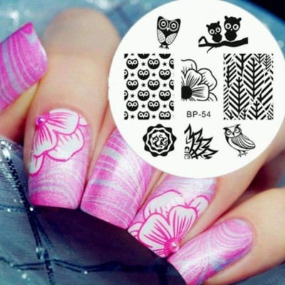 Unhas rosa decoradas com flores e disco branco com estampas pretas