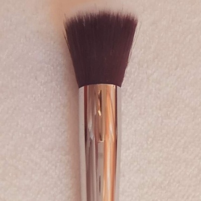 Pincel de maquilhagem com cerdas brancas e pretas e cabo metálico prateado