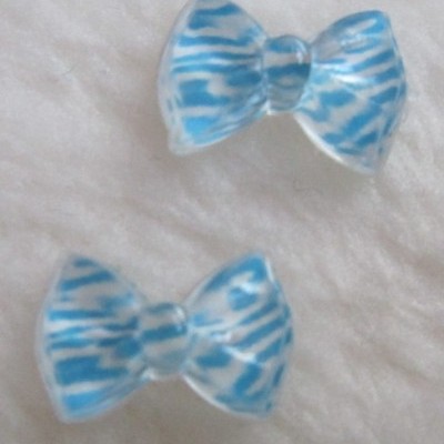 Dois laços de plástico azul e branco sobre superfície macia clara