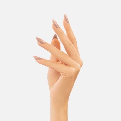 Mão feminina com unhas pintadas de cor creme rosado