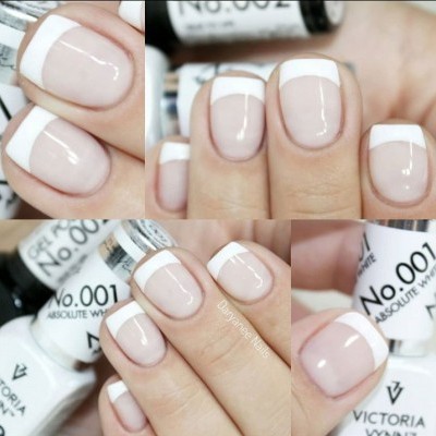 Unhas com francesinha branca e frascos de esmalte branco Victoria Vynn.