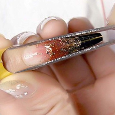 Pincel de maquilhagem em estojo transparente com unhas decoradas