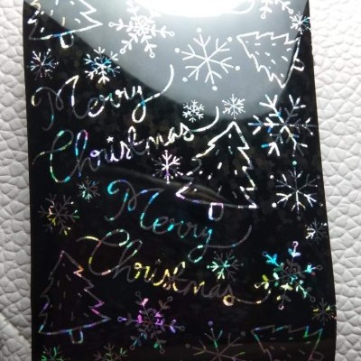 Rolo de papel preto brilhante com desenhos holográficos de Natal